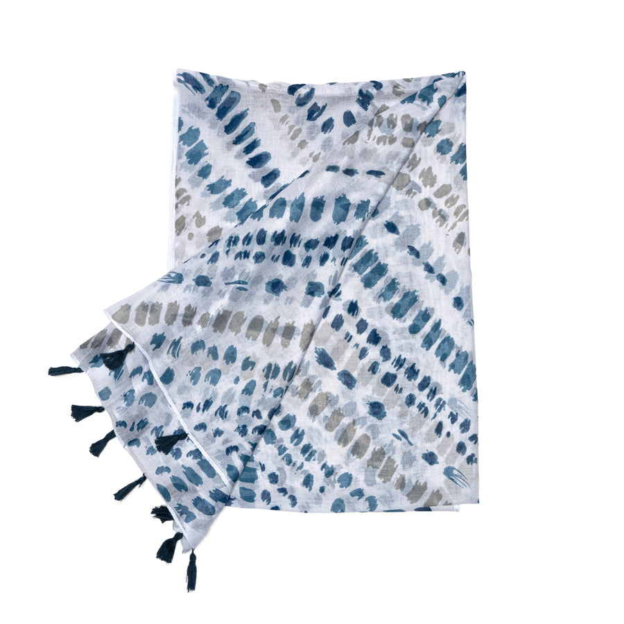 A white scarf with diagonal lines of blue and grey brushstrokes. The edge has sparse navy tassels.