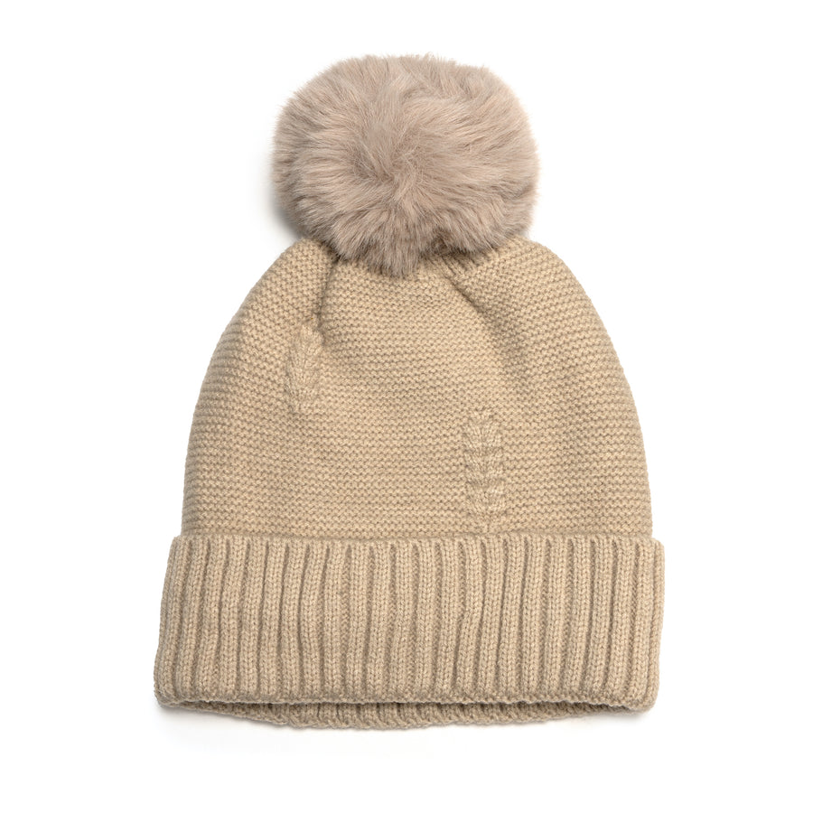 A tan knit hat with tan faux fur pompom.