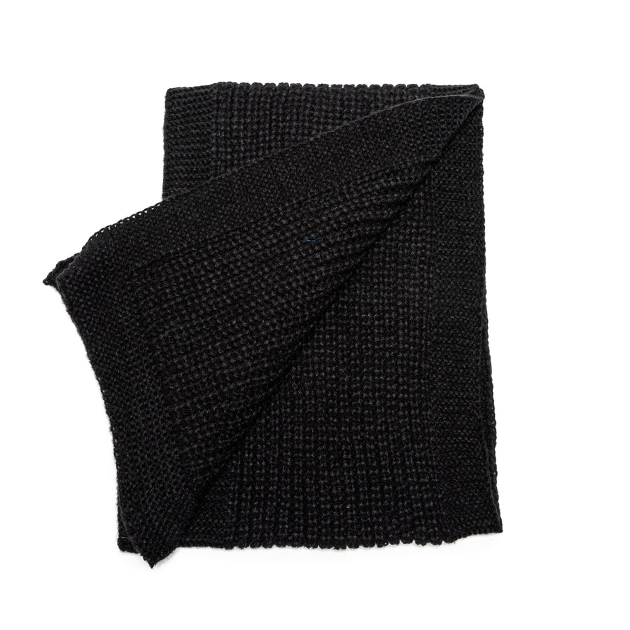 A black knit scarf with knit border.