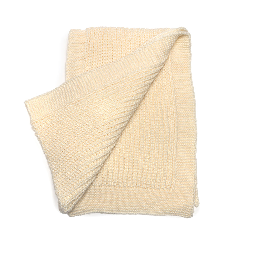 A cream knit scarf with knit border.
