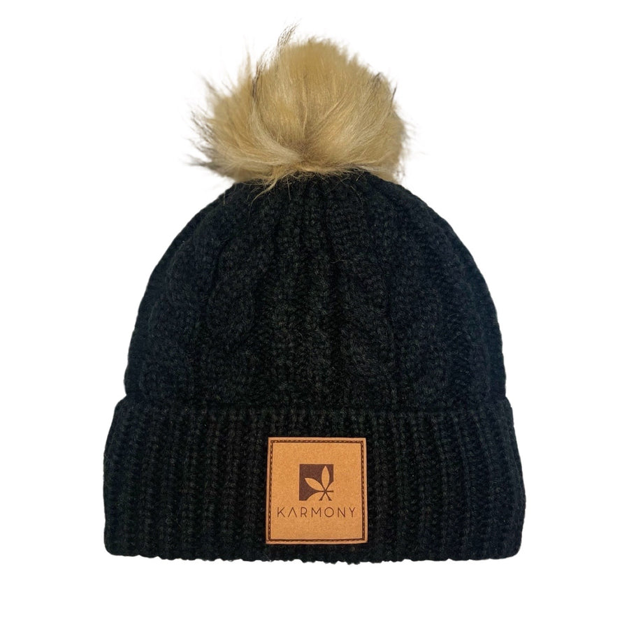 Black cable knit beanie with faux fur pompom.