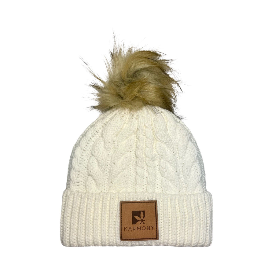 Cream cable knit beanie with faux fur pompom.