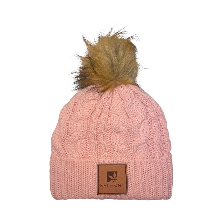 Pink cable knit beanie with faux fur pompom.