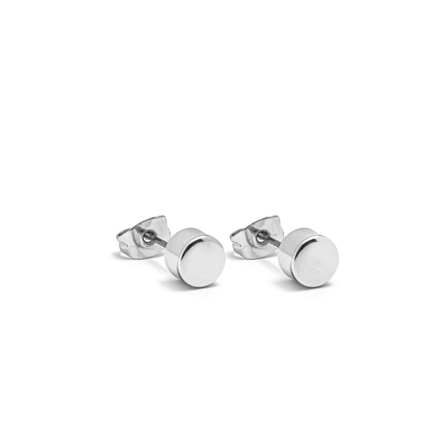 A pair of polished silver cylinder stud earrings.