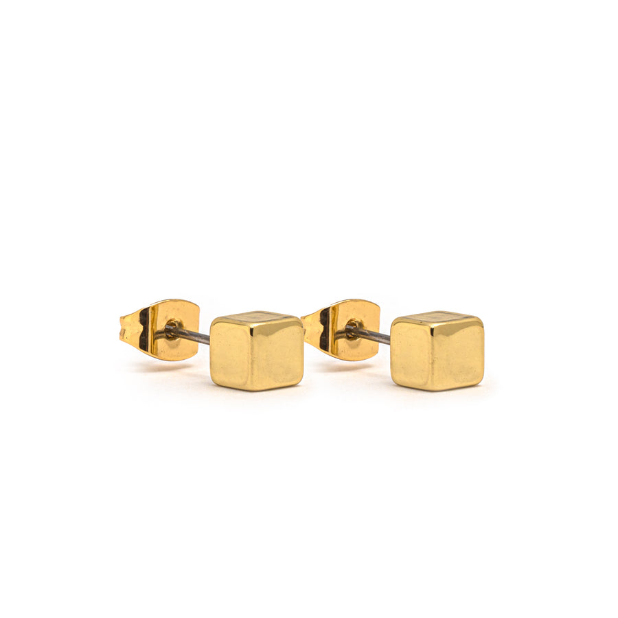 A pair of gold stud earring. The studs are cubes.