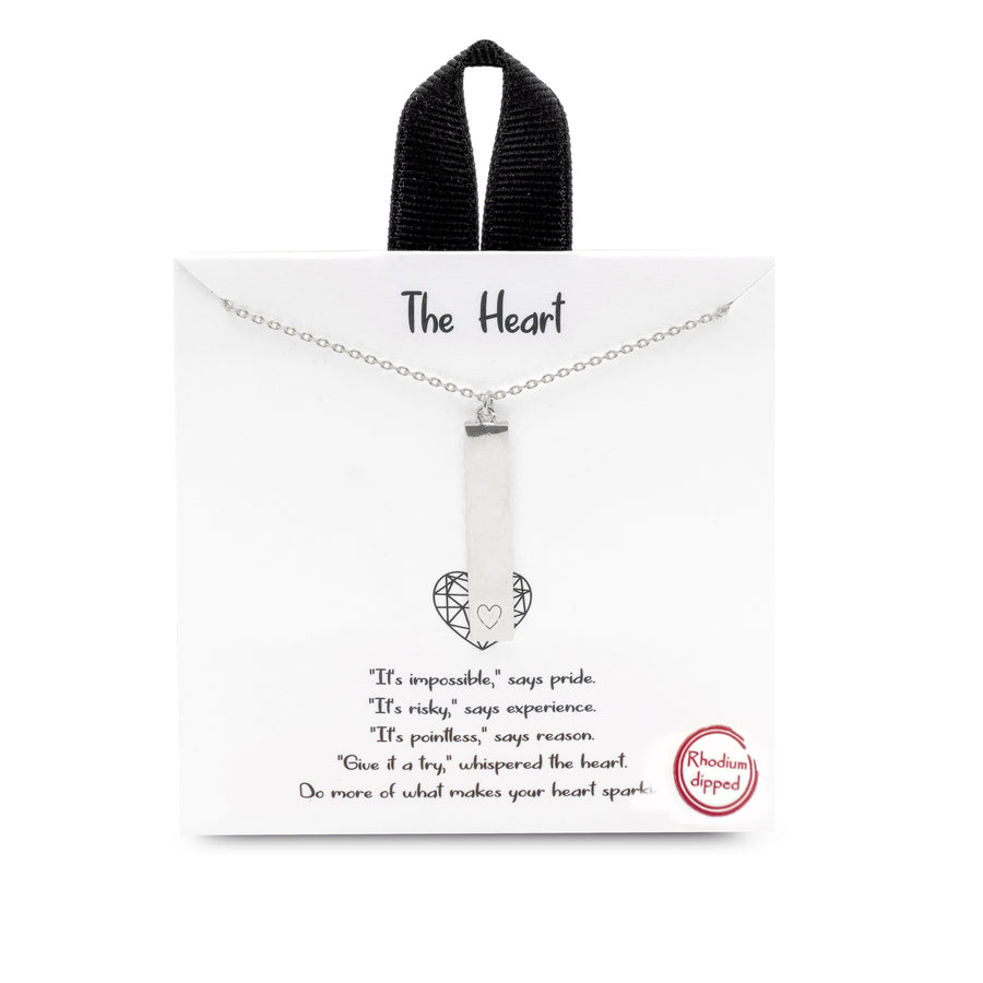 A silver charm necklace. The charm is a vertical bar with a small heart etched on the bottom.