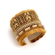 A thick cuff bracelet with tan beaded designs and fringe.