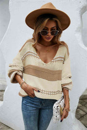 A baggy knit sweater of khaki and cream horizontal stripes. The stripes are of varying widths.