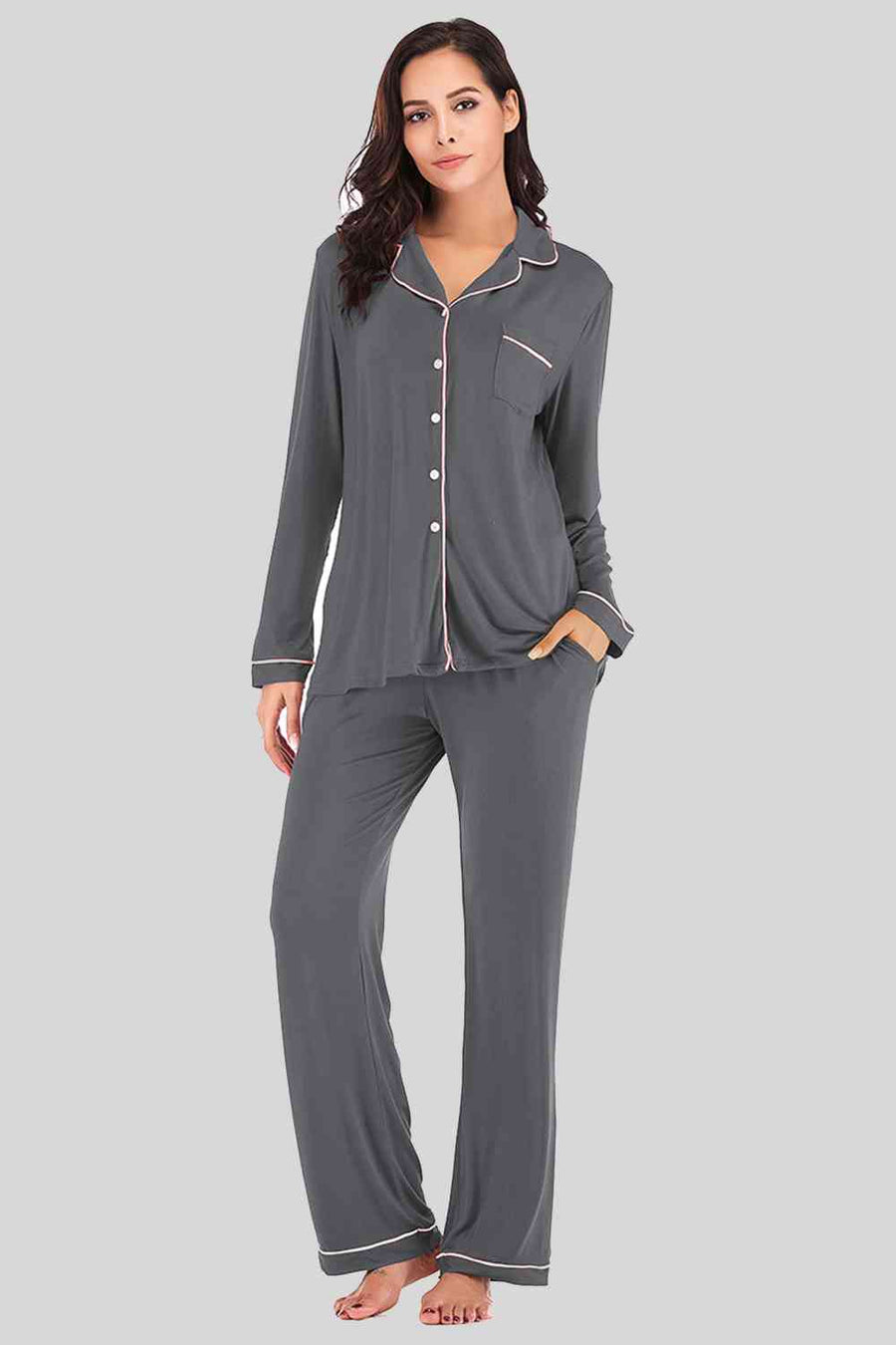 Grey pajama pants and button down top. Features white piping and breast pocket.