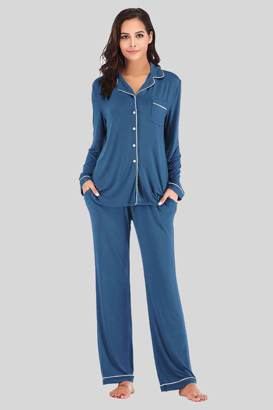 Peacock blue pajama pants and button down top. Features white piping and breast pocket.