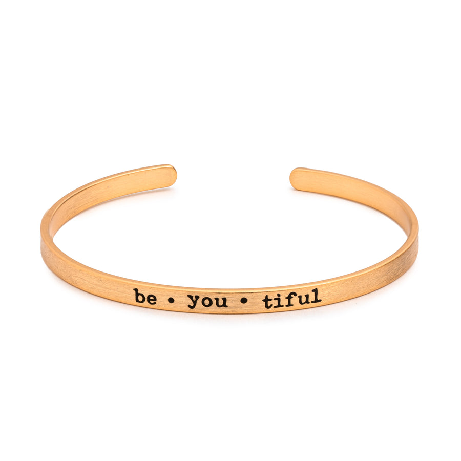 Sentimental Silver Fearless Slim Cuff Bracelet in matte gold with "be•you•tiful" text inscribed in black lettering on white background