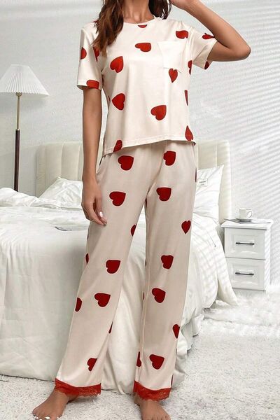 Two piece pajama set with red printed hearts scattered across it. Short sleeve top with breast pocket. Long pants with lace cuffs.