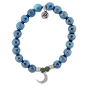 A T. Jazelle bracelet with a silver crescent moon charm  and shimmering, faceted bright blue beads.