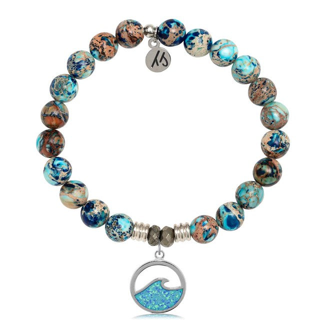 A T. Jazelle Bracelet with a round, silver charm with an iridescent blue wave and marbled blue-and-brown beads.