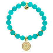 A T. Jazelle bracelet with a round, gold north star charm against a pearlescent inlay and translucent bright teal beads.