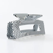 A black-and-white checkered rectangular claw hair clip. 