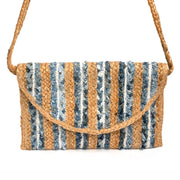 An envelope clutch, with vertical stripes of braided jute and denim. There is also a braided shoulder strap.