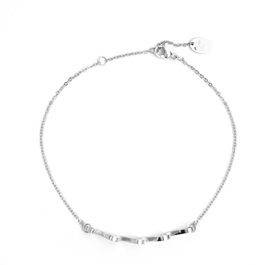 overhead view of silver Wave Anklet with chains attached on either side of a sequence of 3 waves with lobster claw hook on white background